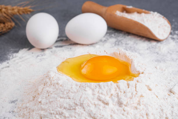 istock Cooking dough. Fresh egg is added to flour. 1211842388