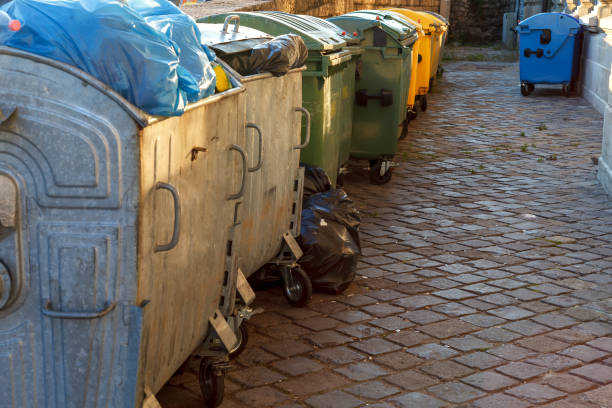 istock Garbage bins line up on a residential street 1211844772