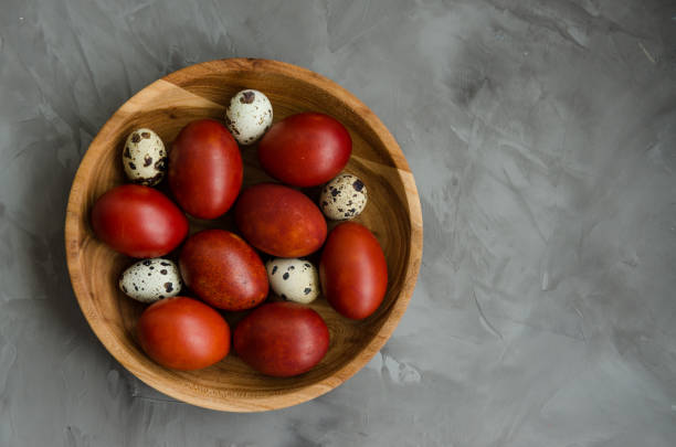 Easter concept. Natural Easter eggs in a wooden bowl cooked in onion peels on a dark stone background. Horizontal orientation. Selective focus. Top view. Copy space