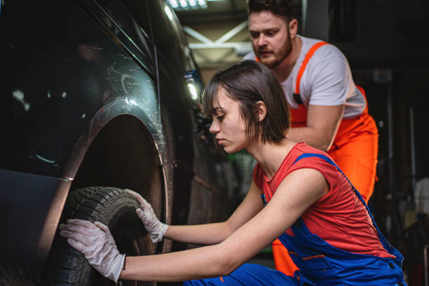 istock Woman learning how to change a car tyre 1211850132