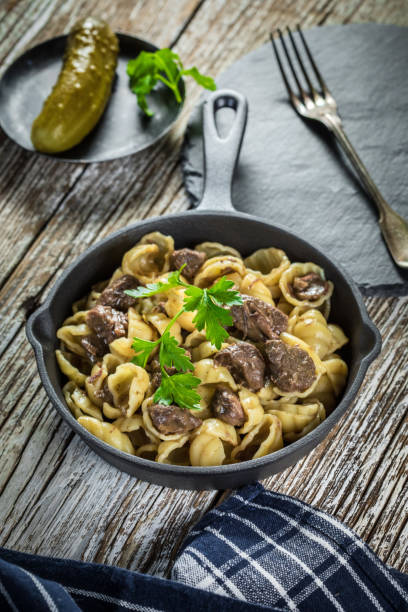 istock Italian pasta shells with beef sauce in cast iron pan. 1211850444