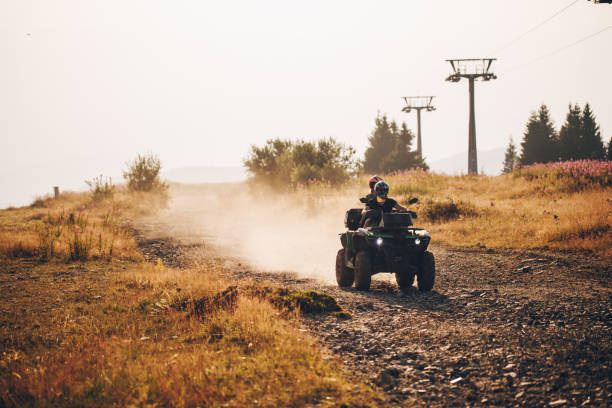 istock Couple exploring the mountain top while riding on a quad bike 1211851080