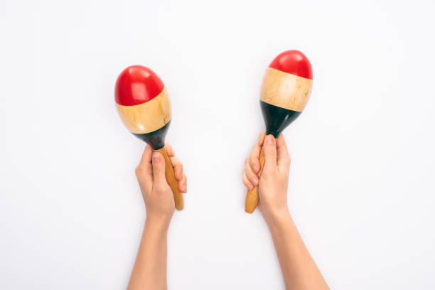 Cropped view of woman holding maracas on white background Cropped view of woman holding maracas on white background maraca stock pictures, royalty-free photos & images