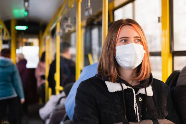 istock Young adult commutes in a protective face mask. 1211859096
