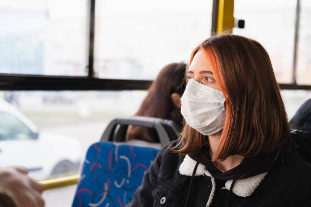istock Woman commutes in a protective face mask. 1211859102