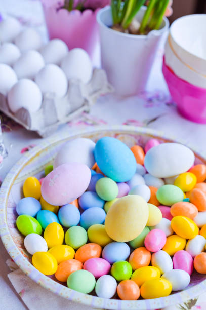 istock Bright colored eggs, large and small for Easter Sunday. Traditional treats. Copy space. Vertical photo. 1211860130
