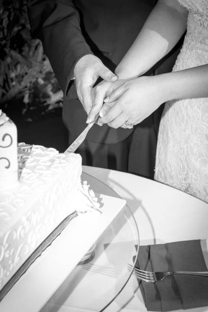 istock Bride and groom cutting wedding cake together 1211860899
