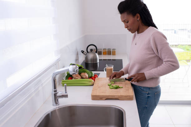 istock Woman preparing salad on the kitchen countertop. 1211861643