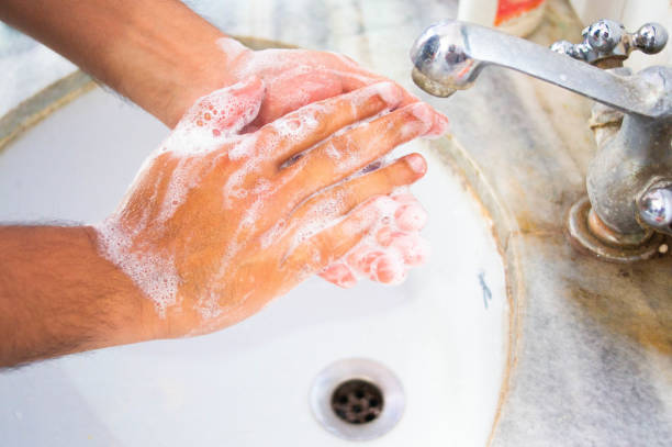 istock Indian person washing hands in a white coloured sink 1211861942