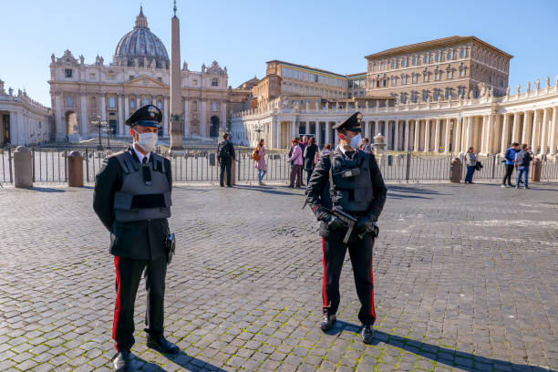 A police patrol check the entrance to St. Peter's Square closed due to the Covid-19 lockdown Vatican, Italy, March 11 -- An Italian police patrol controls access to the square of St. Peter's Basilica, closed to pilgrims and tourists due to the coronavirus emergency in Italy. church of san pietro photos stock pictures, royalty-free photos & images