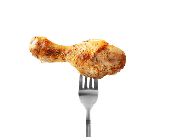 istock Baked chicken drumstick on a fork isolated on white background 1211866156