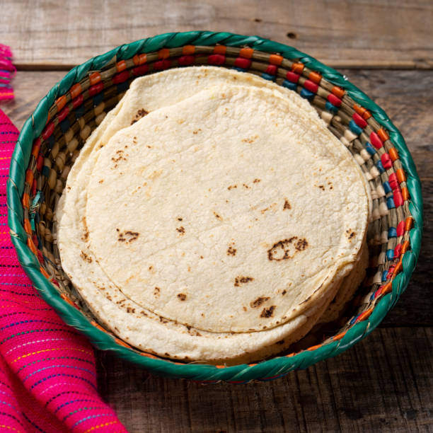 istock Mexican corn tortillas on wooden background 1211867894