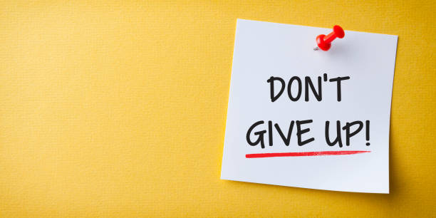 istock White Sticky Note With Don't Give Up And Red Push Pin On Yellow Background 1211869145