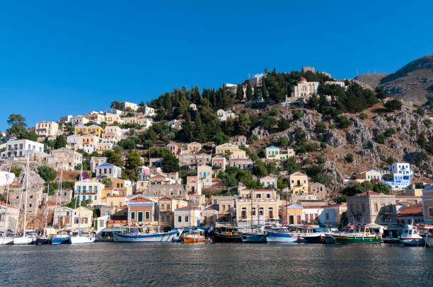 istock Building facades surrounding harbour Symi Town 1211870787