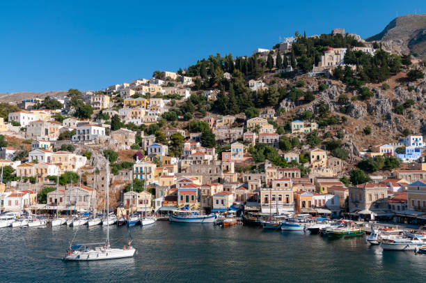 istock Building facades surrounding harbour Symi Town 1211870802