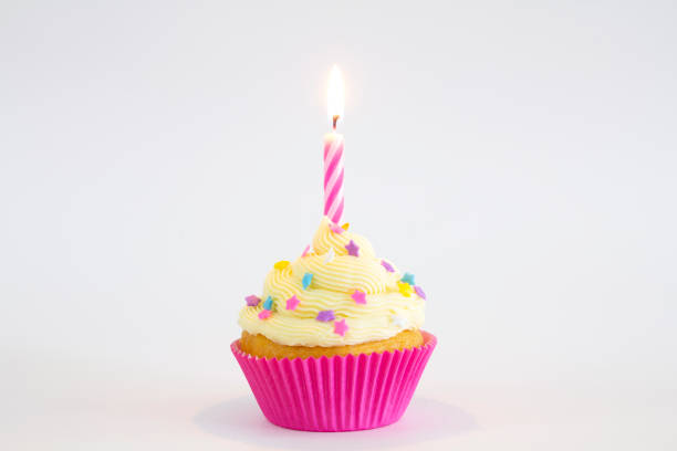Party cupcake with candle A vanilla and buttercream cupcake with sprinkles, and a lit birthday candle. cupcake candle stock pictures, royalty-free photos & images