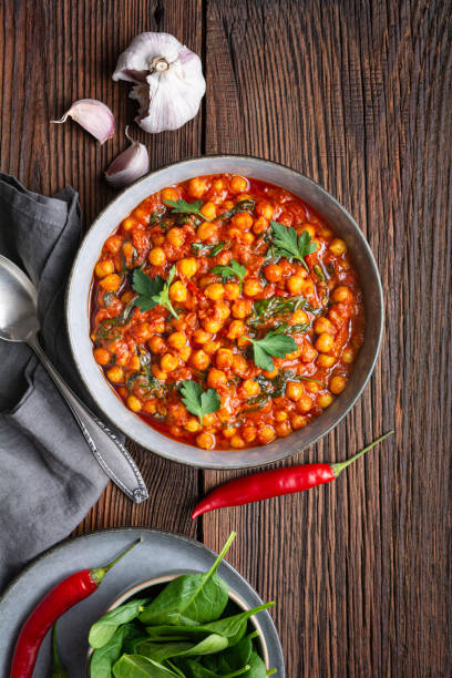 인도 요리, 매콤한 병아리콩 카레와 시금치를 그릇에 담습니다. - tomato curry 뉴스 사진 이미지