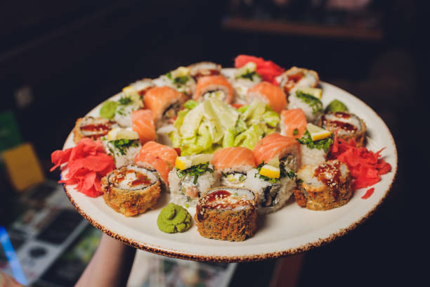 istock Sushi and rolls in plate on a black background. 1211877589