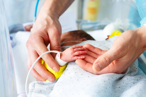istock Fathers hand close-up with sick newborn child 1211877746
