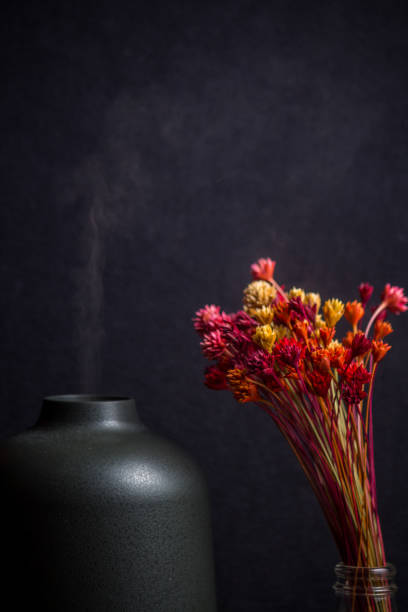 istock Electric Essential oils Aroma diffuser, oil bottles and flowers on wooden table, space for text. 1211881334