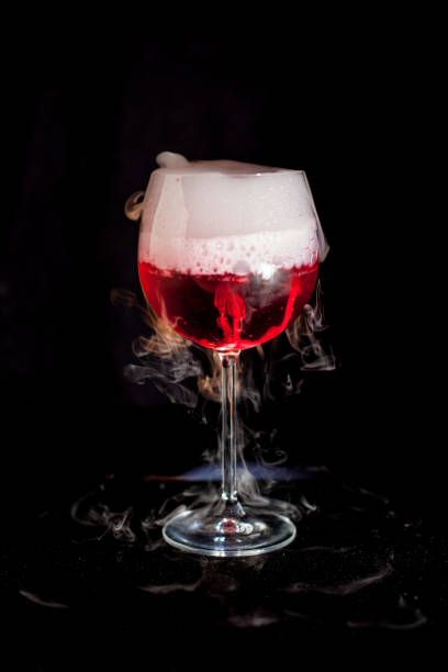 istock A cup of red cold cocktail with dry ice smoke 1211883896