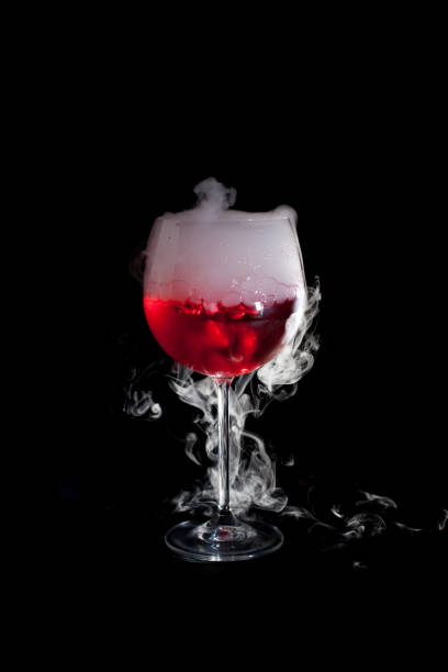 istock A cup of red cold cocktail with dry ice smoke 1211883907
