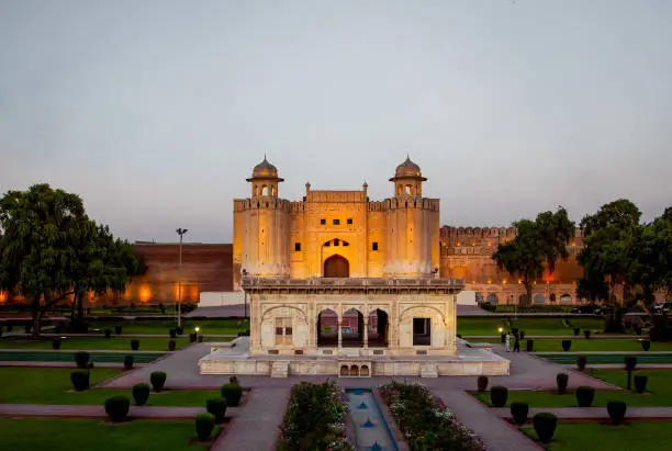 Iconic Alamigiri Gate of  the Fort at sunset, Lahore, Pakistan in the sunset time with a pavilion in front in the garden. A UNESCO World Heritage Site.