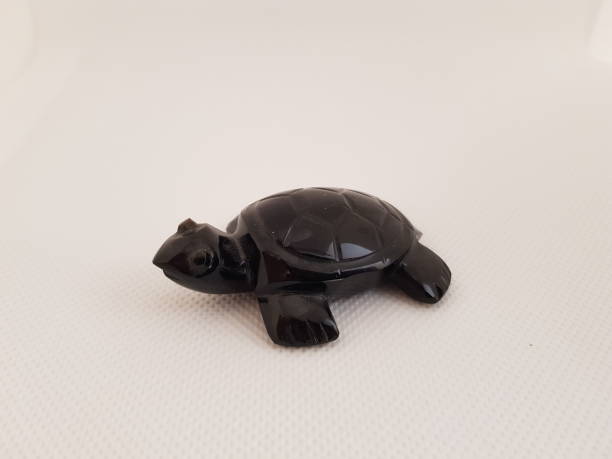 istock A turtle made of obsidian on a white background 1211886572