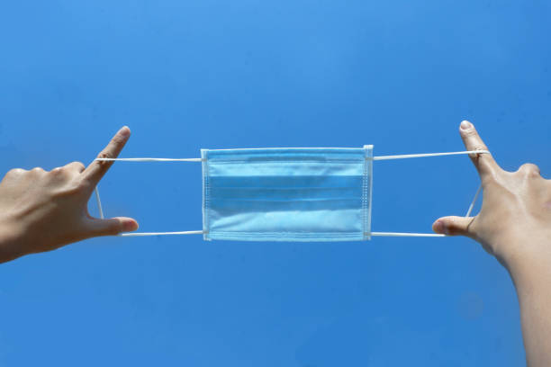 istock Surgical face mask in fresh air with blue sky. 1211903034