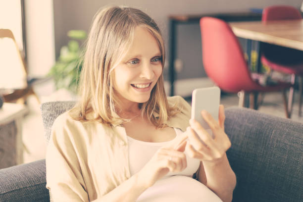 istock Happy excited expectant mother using cellphone for selfie 1211909141