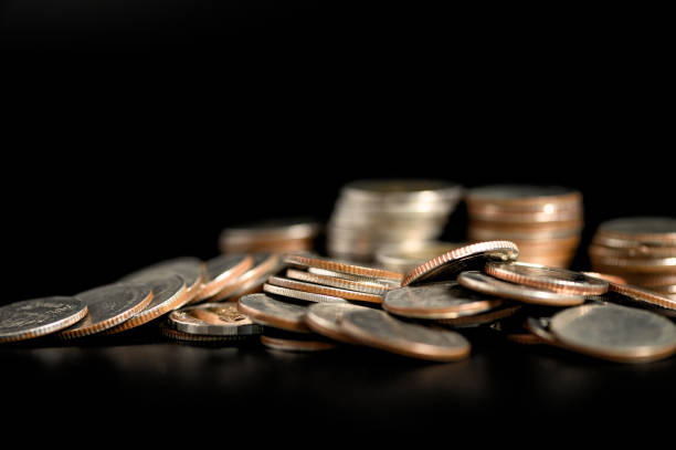 istock Pile of coins on black background 1211911182