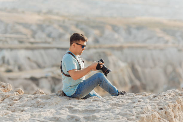 istock photographer sits on rock in Cappadocia 1211913988