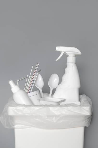 istock Trash bin for recycling with trash made of white plastic on a gray background. 1211917149