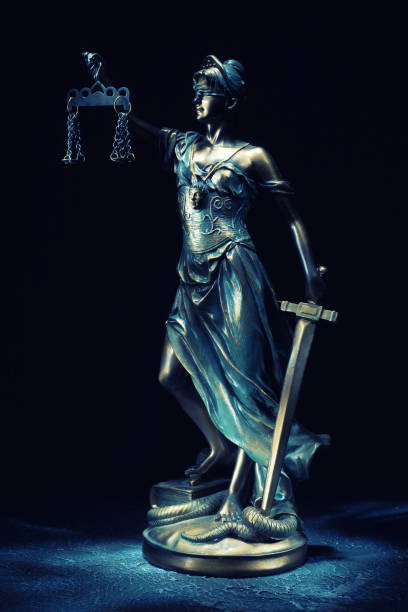 la statuetta di themis si erge sul vecchio tavolo in pietra d'epoca. - justice is blind foto e immagini stock