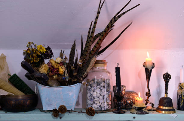 istock Witch altar with burning candles, dry herbs and feathers. 1211922902