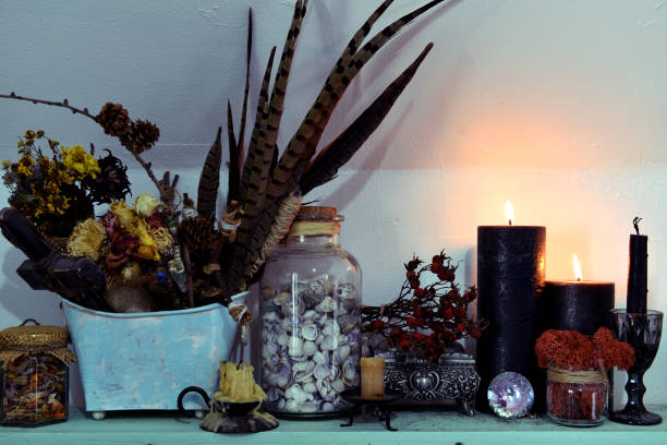 istock Black candles, feathers and shells in glass jar on the shelf. 1211922931