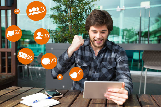 istock Happy man using tablet and celebrating success in outdoor cafe 1211927255