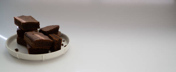 istock Chocolate brownie sliced into square slices on a white plate 1211927739