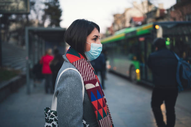 mulher na cidade usando máscara facial protetora. - smog city pollution town - fotografias e filmes do acervo
