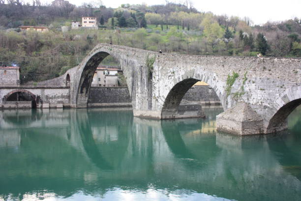 le suggestif et célèbre ponte della maddalena de lucques construit en briques sur une rivière dans un ancien village médiéval à borgo a mozzano - magdalena photos et images de collection