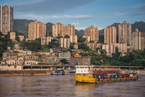 Cargo ship arriving in Chongqing city Chongqing, China - August 2019 : Huge cargo ship transporting large shipping containers departing port in Chongqing city chongqing stock pictures, royalty-free photos & images