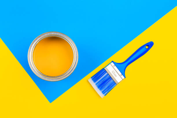istock Yellow  Paint Can with Brush Top View On multicolor Background. 1211935662