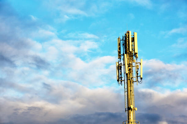 A mobile phone relay tower rises against gathering storm clouds.