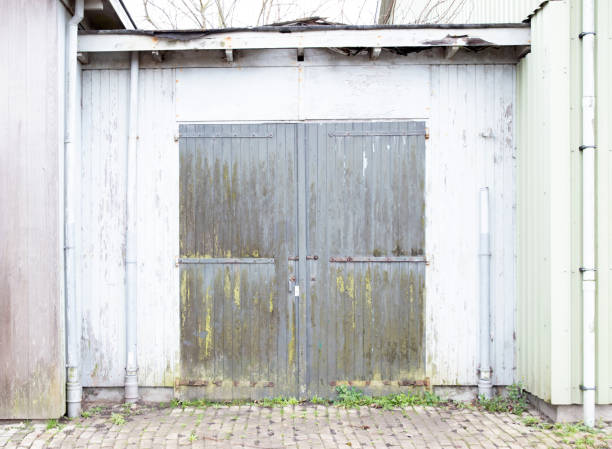 istock Old garage door in a white wooden wall 1211945528