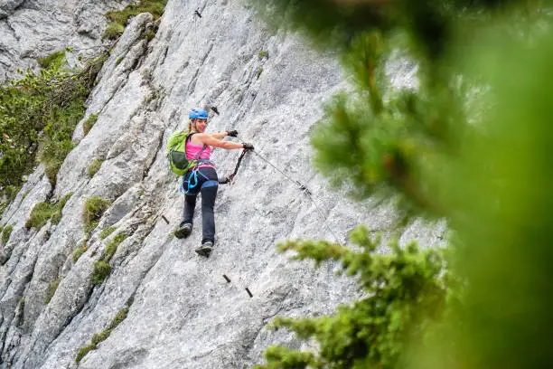 Photo of Woman tourist on a traverse at Intersport Klettersteig Donnerkogel via ferrata route, near Gosau, in Austria.