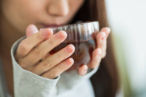 mujer joven bebiendo té - herbal tea fotografías e imágenes de stock