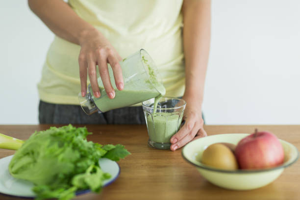 istock Young woman making a green smoothie 1211948306