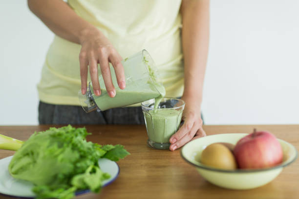istock Young woman making a green smoothie 1211948313