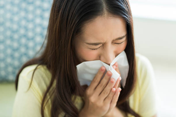 istock Young woman blowing nose 1211948376