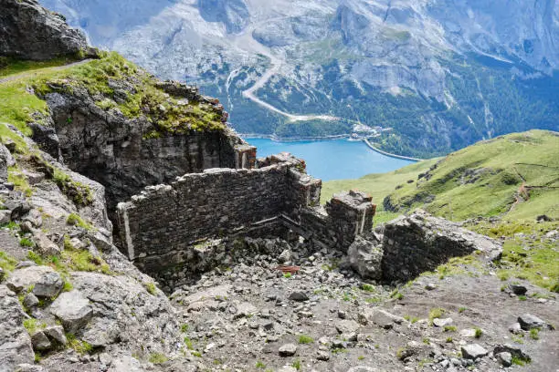 Historic World-War I fortifications on via ferrata Delle Trincee (meaning Way of the trenches), with lake Fedaia down below, in Trentino, Dolomites mountains, Italy.
